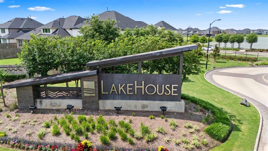 Stylish entrance monument at LakeHouse with modern design and lush greenery sets the tone for luxury living.