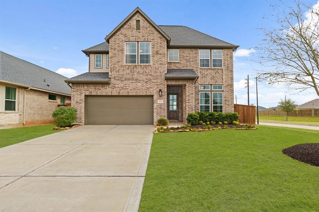 Gorgeous brick exterior with two-car garage, tidy landscaping, and great curb appeal on a prime lot in LakeHouse.