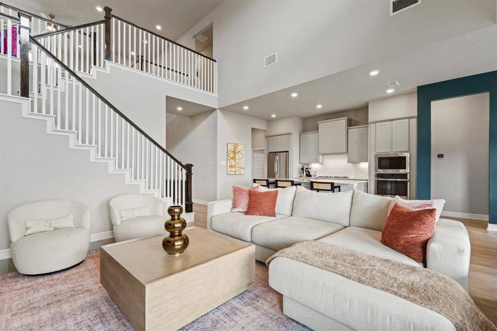 This stunning open-concept living area features soaring ceilings, elegant finishes, and a seamless flow into the gourmet kitchen—perfect for both entertaining and everyday living.