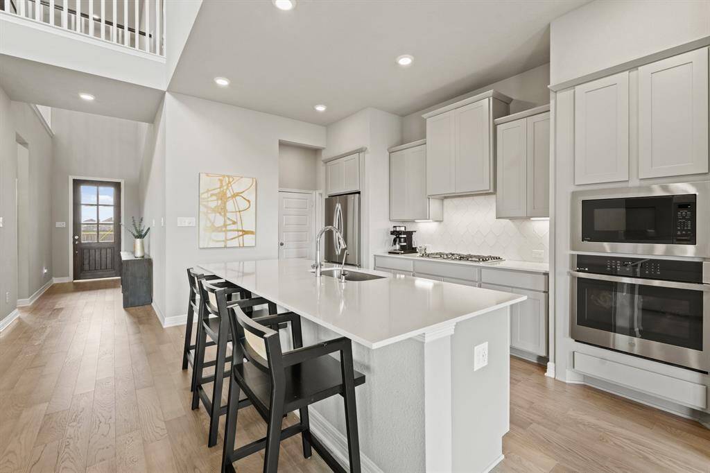 This modern kitchen features sleek cabinetry, a spacious island with seating, stainless steel appliances, and elegant finishes perfect for both cooking and entertaining.