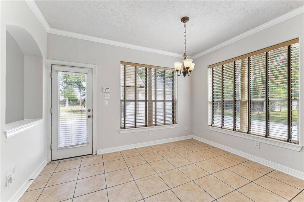Breakfast room with large windows overlooking the back yard and driveway.