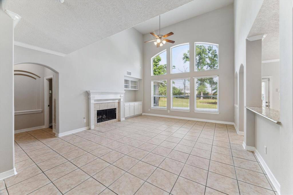 Grand family room featuring a gas log fireplace, high ceilings and a abundance of natural light.