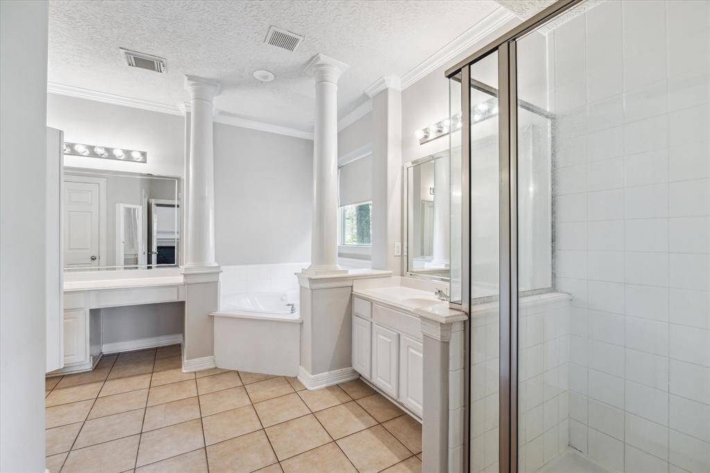 Luxurious primary bath featuring a relaxing tub and spacious walk-in shower