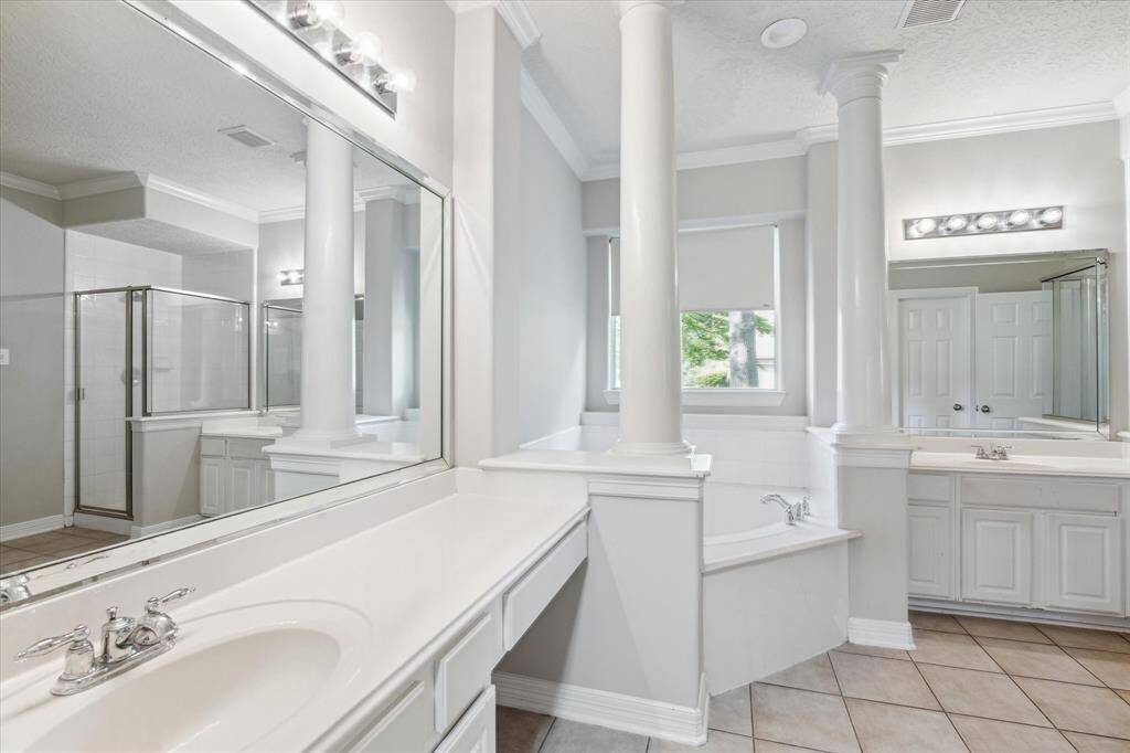 Primary bath also features double sinks with vanity.