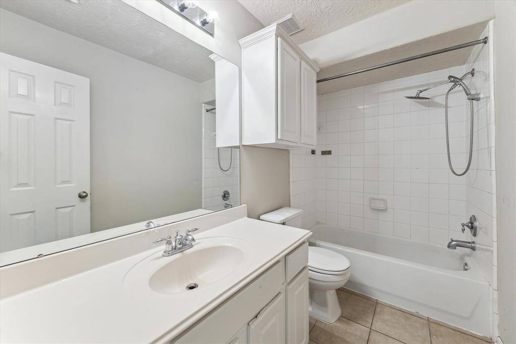 Secondary bathroom tucked away near a bedroom features a single vanity with  a combination tub/shower.