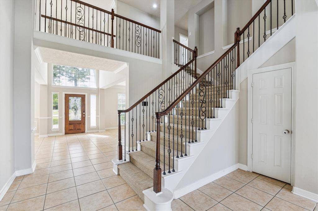 You will love the grand staircase with wood and wrought-iron railings, leading to the upper level.