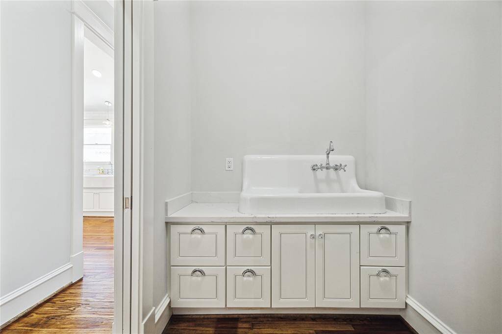 Walk-in utility room features gas & electric dryer hookups and this antique service sink with plenty of extra storage.