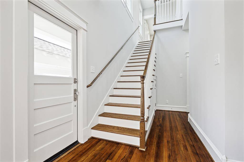 This staircase off the kitchen leads to the second Primary Suite and a guest suite upstairs.