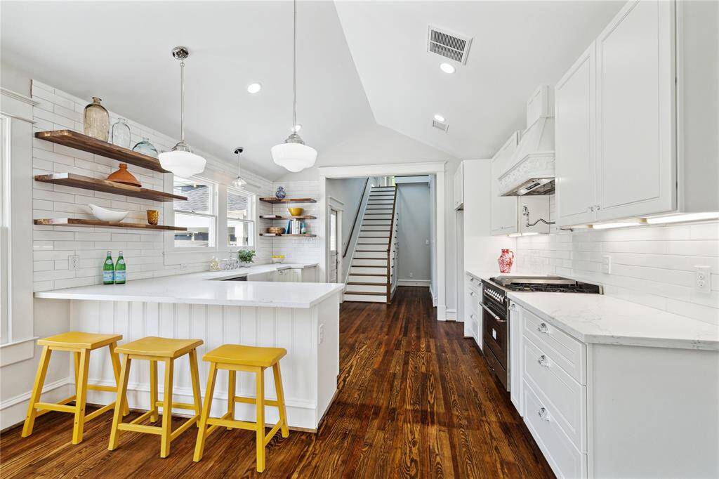 The large, open kitchen is light and bright with Stainless appliances, pot/pan drawers, quiet close cabinets, open shelving and plenty of counter space,