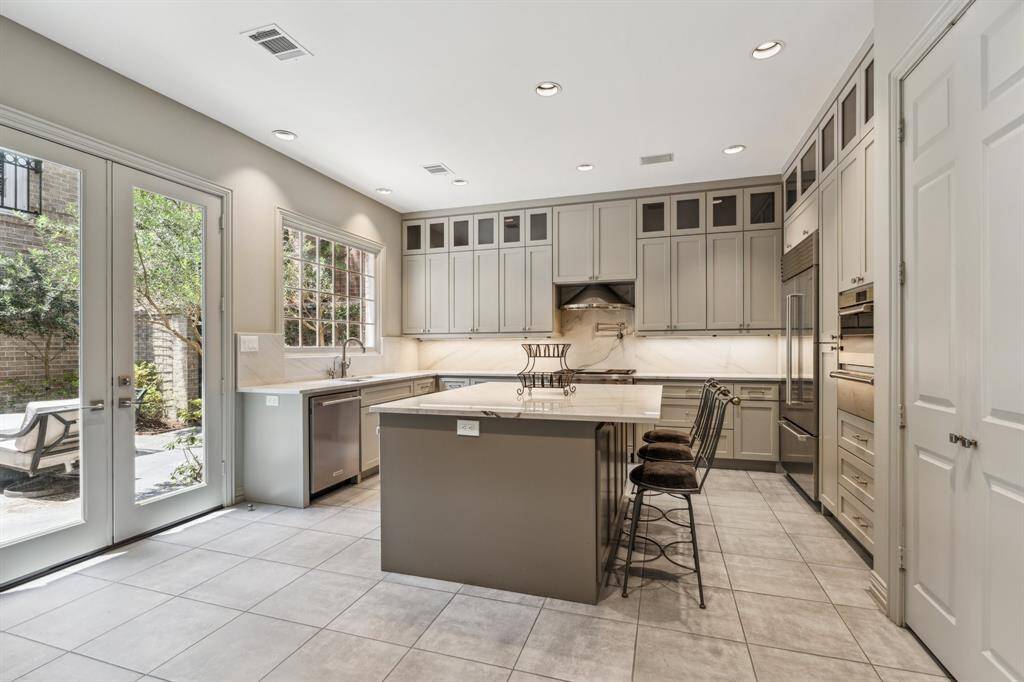Welcome to the heart of the home—the kitchen! A true showstopper with two ovens (one in the professional range and the other oven is a steamer/convection over and a warming drawer), a massive island, and luxe lighting. Everything gleams, and the energy promotes gourmet creativity.