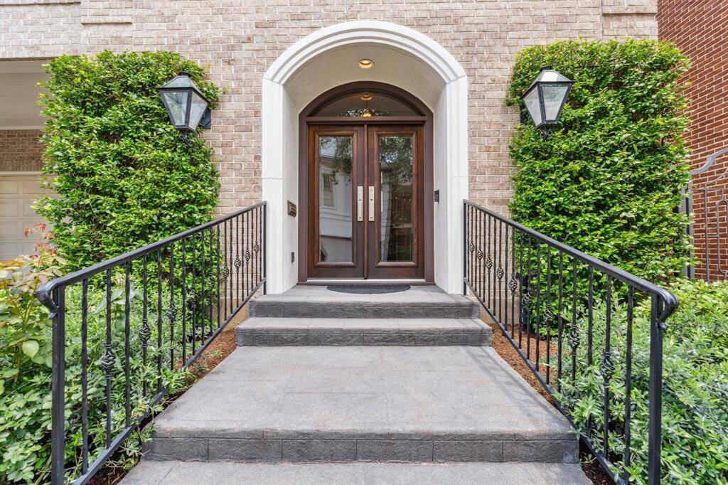 A close up image of the lushly landscaped front walkway area leading to the double beveled glass French entry doors. Gorgeous! The homeowner maintains their own yards, but the HOA includes weekly leaf and debris blowing and outside landscaping including bayou cleanup as necessary (per Seller).