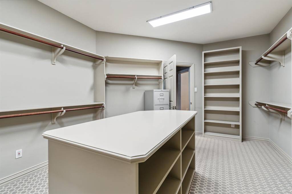 The walk-in closet feels more like a boutique—endless storage, smart built-ins, and perfect lighting. Your wardrobe has never looked so good. This image does not do this closet justice.  Incredible!