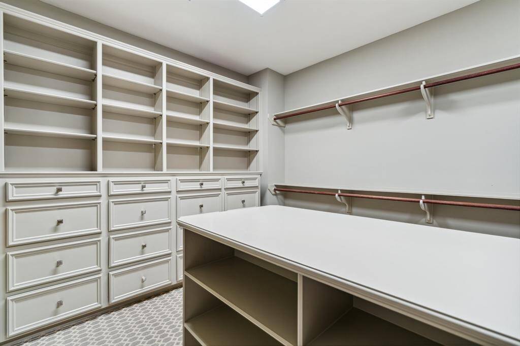 This walk-in closet standouts include custom packing island, built in dressers, single and double hanging rods and so much more.