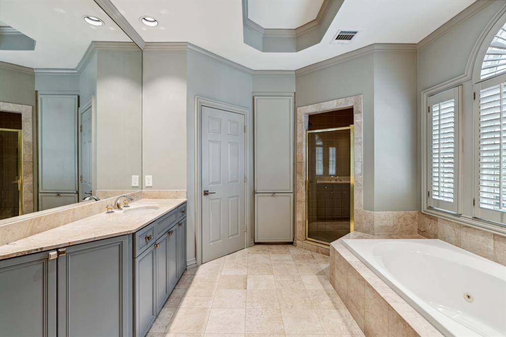 The Primary Bath is luxury personified—gleaming marble vanities, recessed lighting, and a jetted soaking tub that begs for bubbles and a glass of wine. A daily routine never looked so inviting.