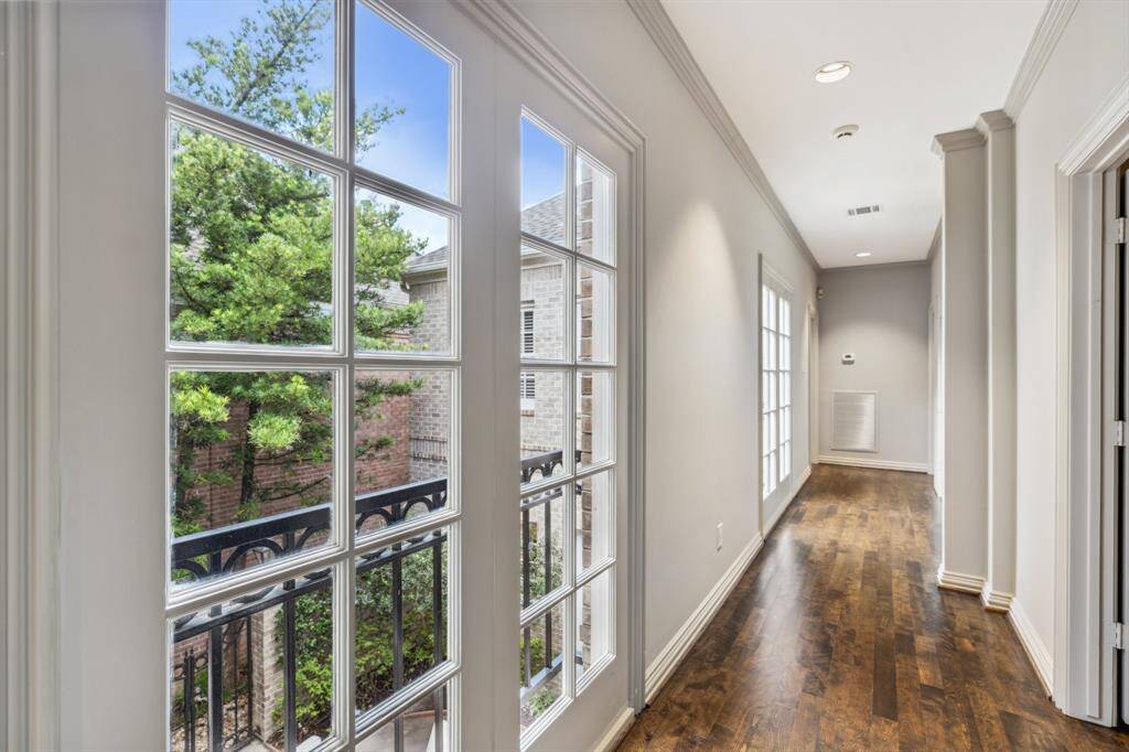The upstairs Gallery offers a wide, welcoming pause with hardwood floor and wonderful natural lighting. It is a great transition zone between the Primary Bedroom suite and the secondary bedrooms at the end of the hall—soft on the feet and easy on the eyes.