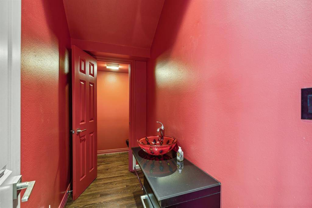 The Powder Room has a separate private water closet with custom paint, glass vessel lavatory on a custom furniture style cabinet.  Located ideally off the Gallery in between the Living Room and the Family Room for the utmost privacy.