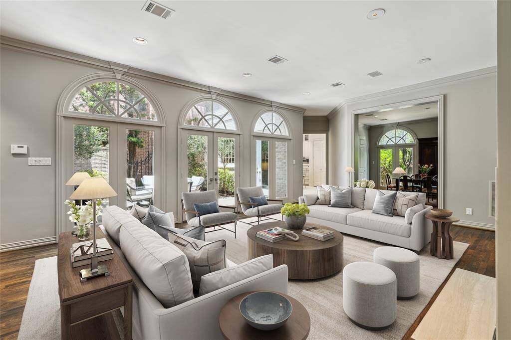 A view of the Family Room (22 x 18) showcases the French Doors to the large patio, access to the gourmet island Kitchen (15 x 12) and the cased opening to the Dining Room (18 x 16).  Large casual and formal living spaces for entertaining or quiet family living. This photo is virtually staged to show one possible configuration of furniture.