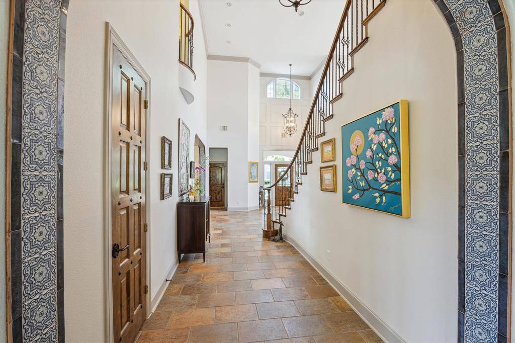 Entry hall with tiled arch opening, custom stained powder bath door with iron nailheads.
