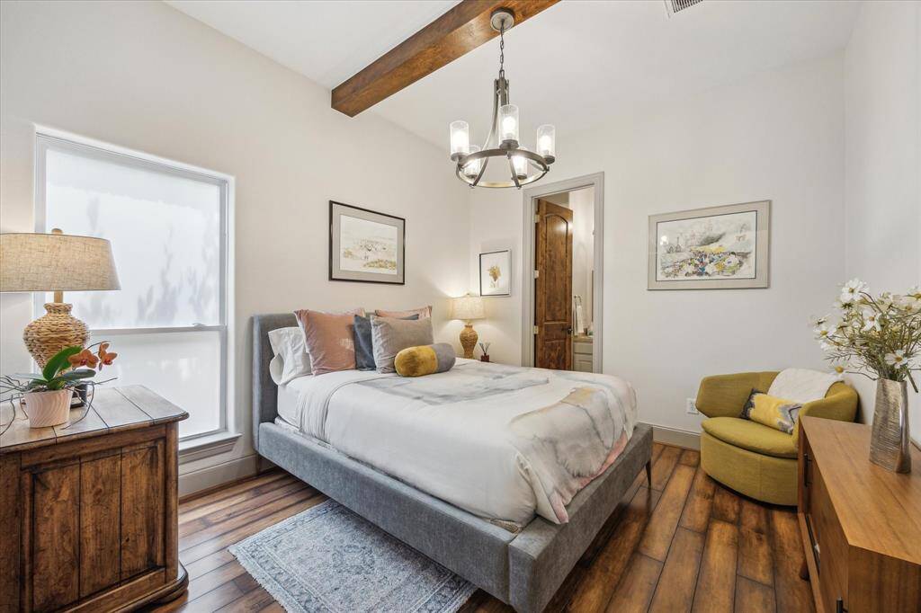 Second bedroom down with beam and chandelier. Spacious closet and en suite bathroom.