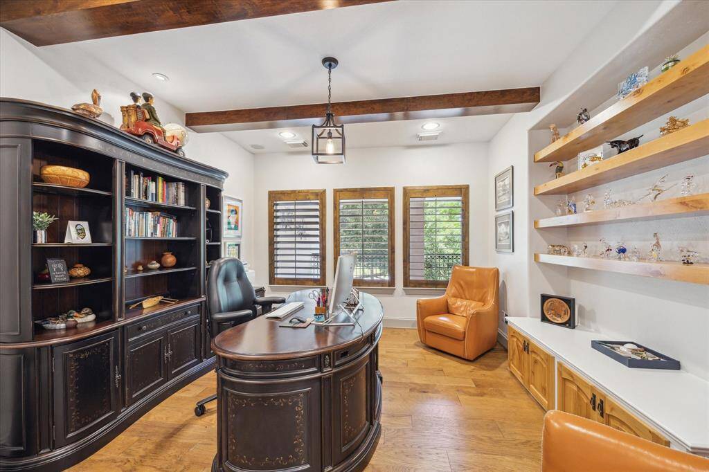 Second floor office with custom floating wood shelving, stained beams and engineered wood flooring.
