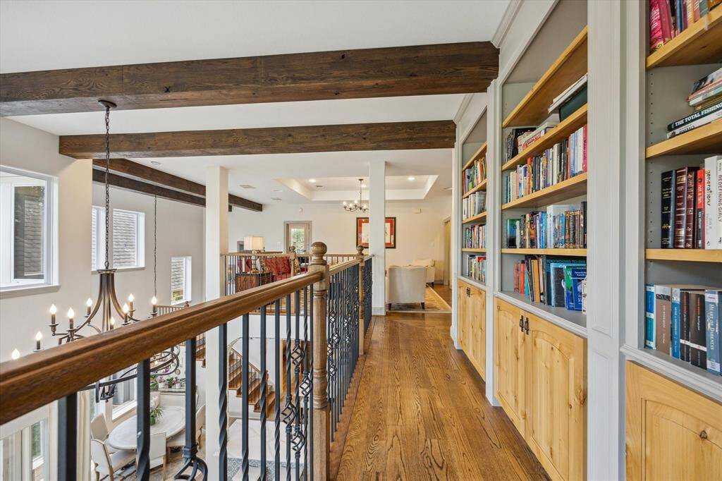Second floor balcony with custom bookshelves and access to game room overlooking the family room and exterior balcony.