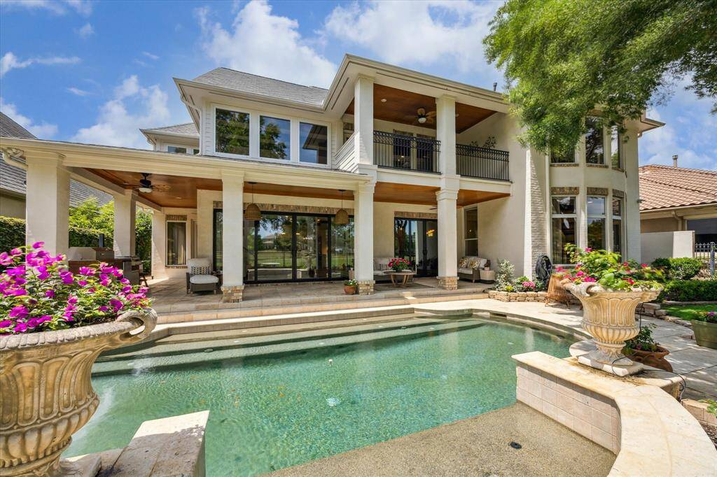 Gorgeous back exterior with covered lanai, hanging lanterns, antiqued bead board ceilings, and sparkling pool.