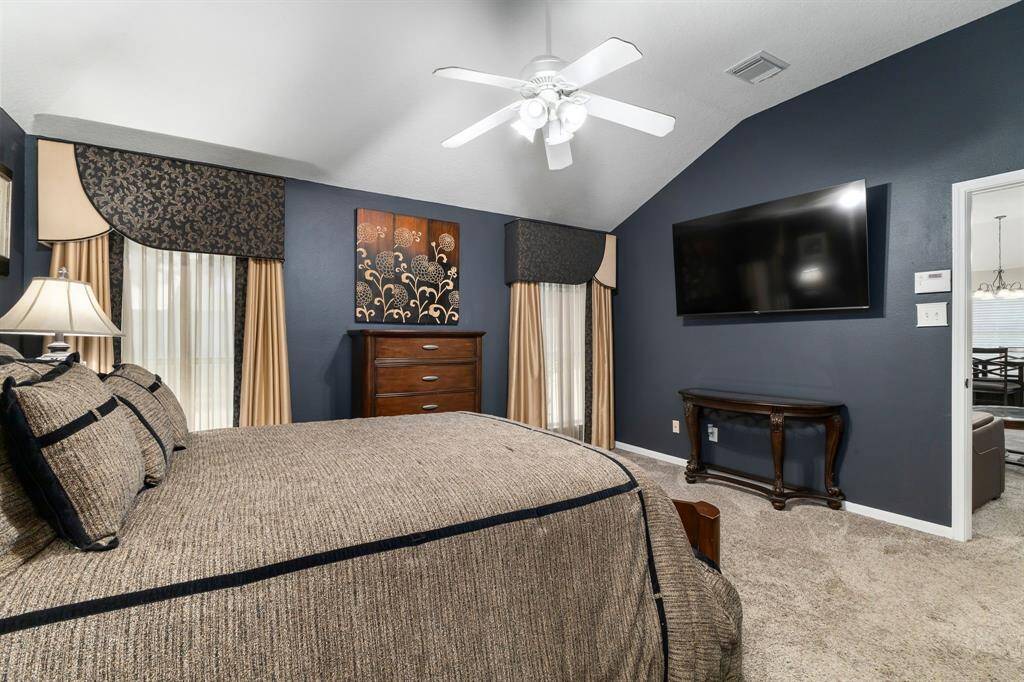 Primary bedroom with elegant window treatments and cozy carpet, offering a stylish and comfortable retreat.