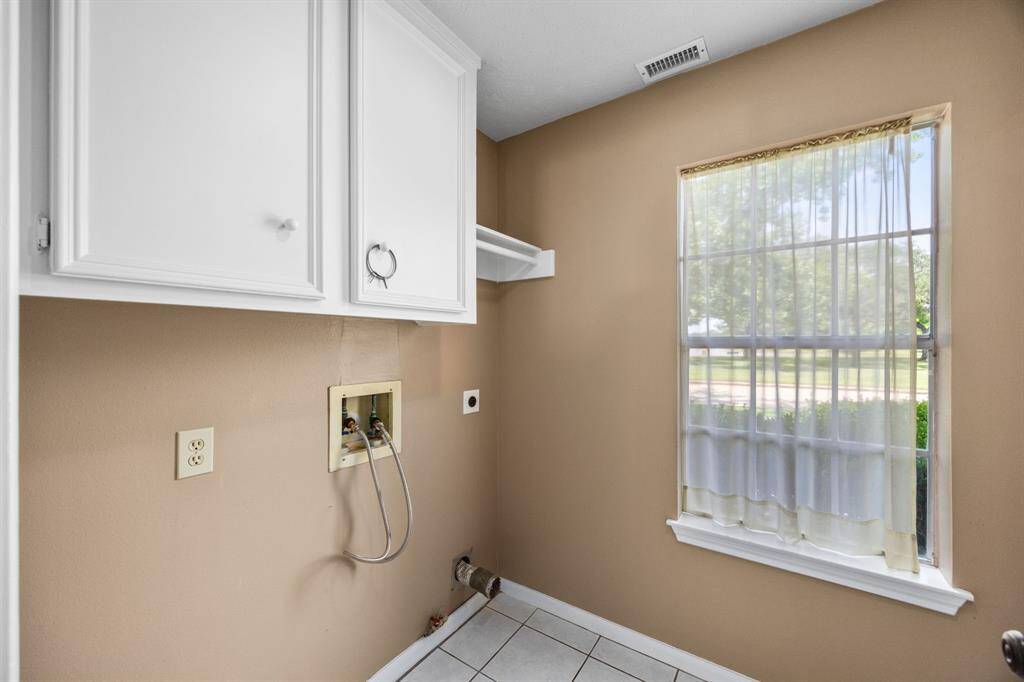 Utility room located off of the kitchen with added storage.