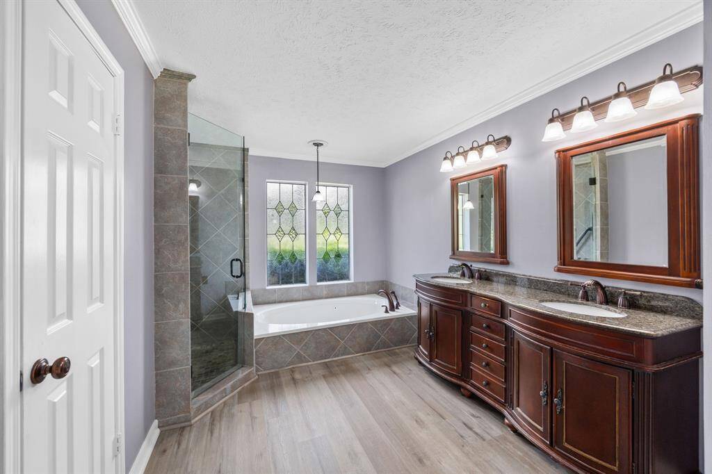 En-suite primary bathroom with double sinks, jetted tub, and separate shower.
