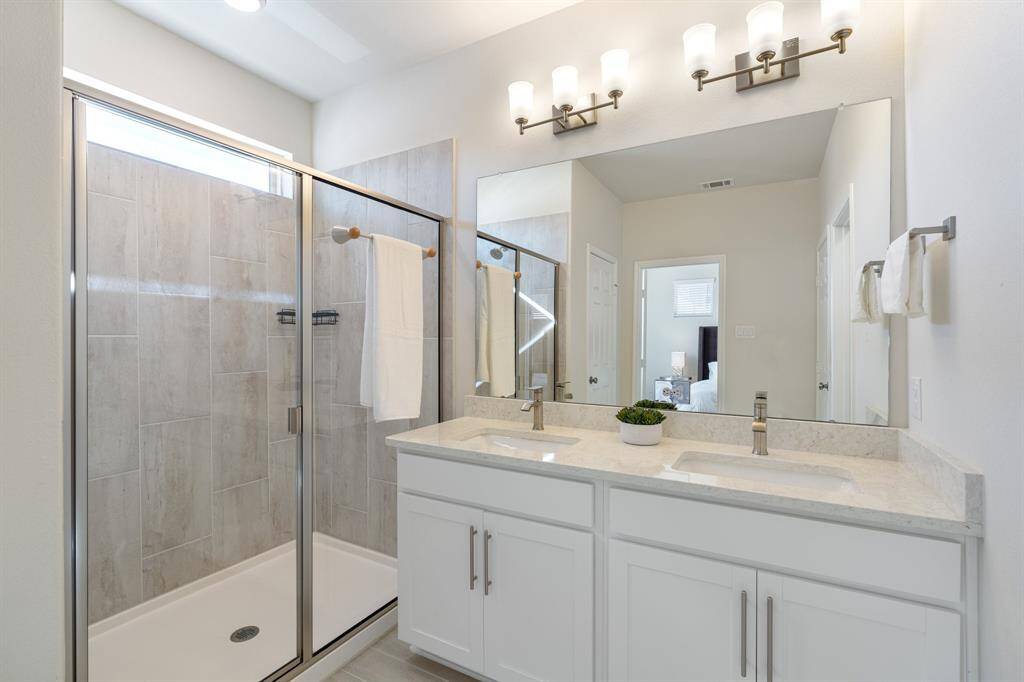 The primary bathroom is  classic and timeless. Features include a dual sink vanity, tiled walk-in shower, natural light.