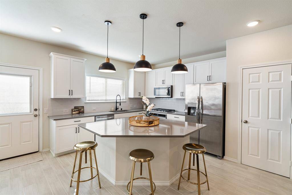Enjoy upgraded stylish lighting over the oversized kitchen island.