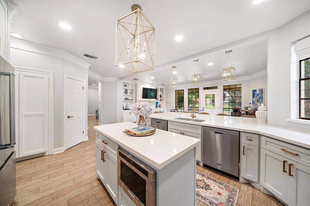 Enjoy an oversized island, custom cabinetry, high-end appliances, and a cozy sitting area perfect for morning coffee.