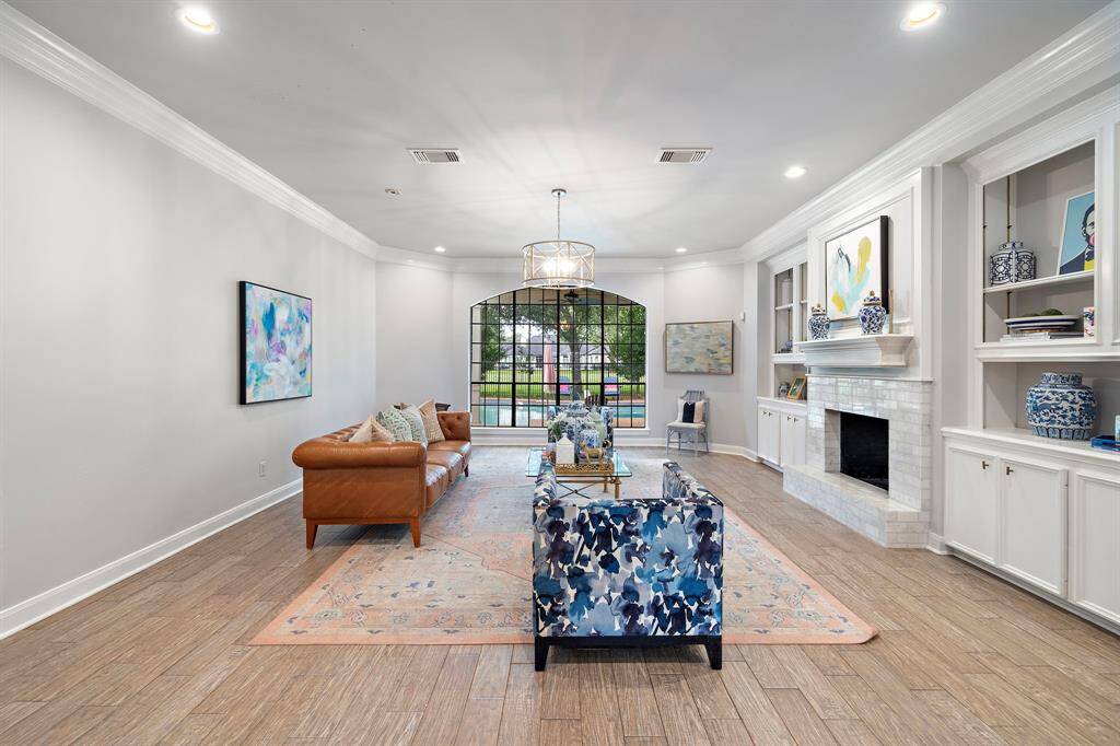 The expansive family room, graced by a stunning double-sided fireplace, flows seamlessly into the gourmet kitchen.
