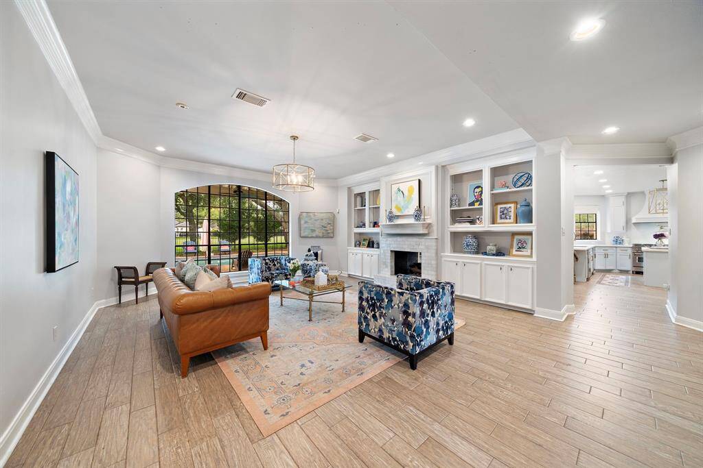 Custom built-ins are seen on both sides of the double sided fireplace.