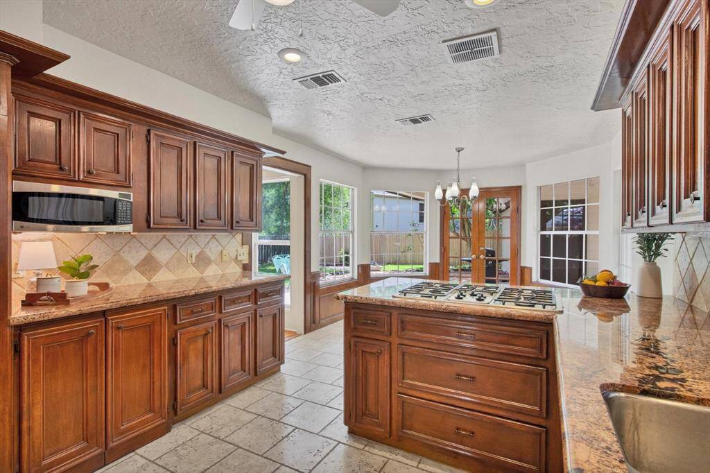 Such a great kitchen remodeled with Brazilian granite counters, porcelain tile flooring, 5 burner gas stove, built in microwave, double oven, large pantry...and the BONUS ISLAND that pulls out from under the microwave counter when needed.  You just open those cabinet doors and roll it out.