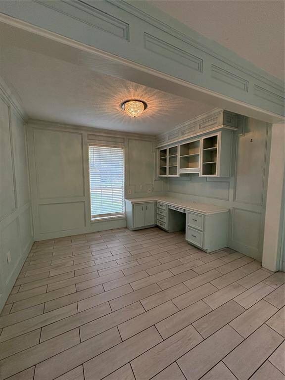 Office space with plenty of storage, a built in desk adjacent to the living room and kitchen.