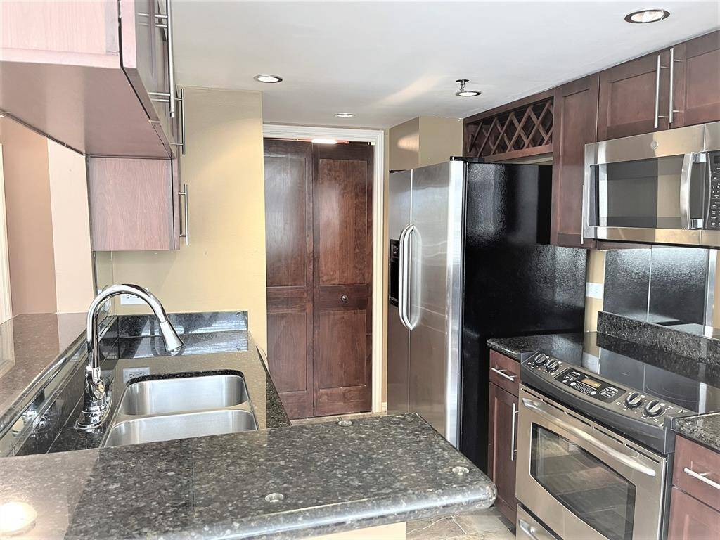 Electric range with glass cooktop and built in microwave oven. Laundry is behind door in the middle.