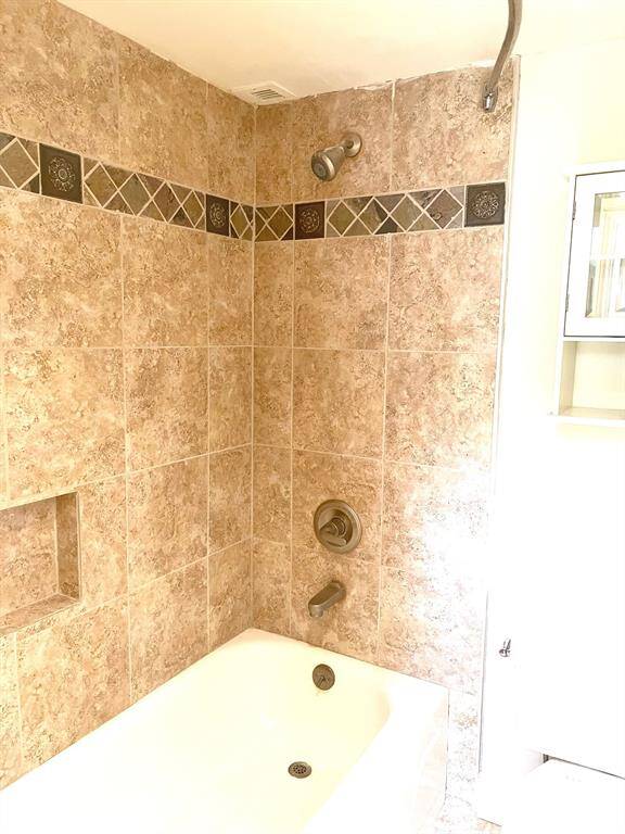 Hall bathtub/shower combination with custom tile surround