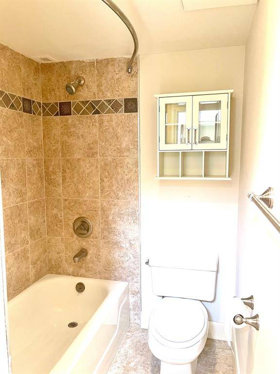 Another view of hall bath with storage cabinet above the toilet