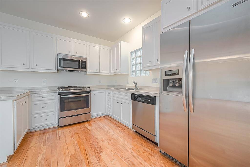 Modern kitchen, spacious with sleek white cabinets, perfect for meal prep.