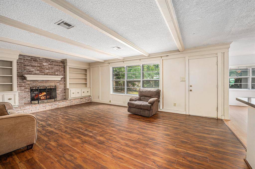 Charming living room with custom built-ins, a cozy fireplace, and great views of the backyard.