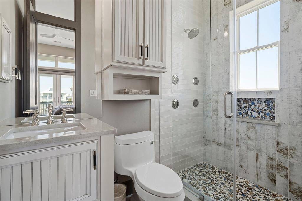 Secondary bath with walk-in fully tiled shower.