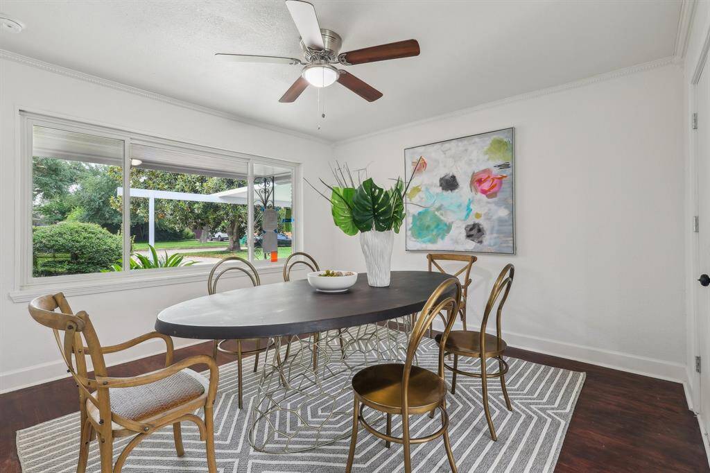 Bright dining room with a large window offering garden views,creating a welcoming and airy atmosphere.