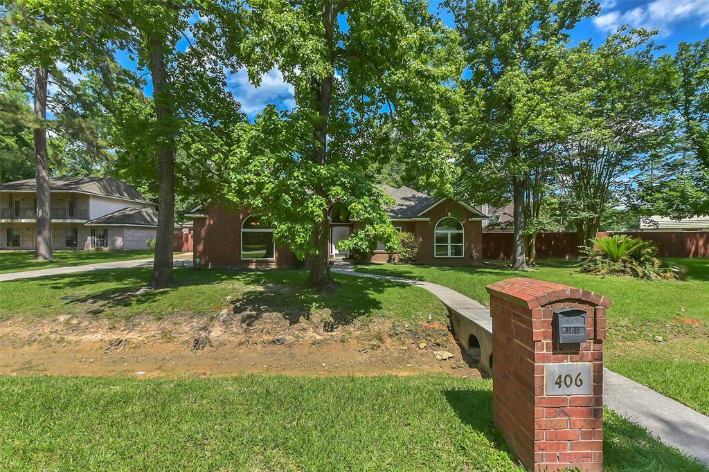 Charming brick home nestled among mature trees, featuring a well-maintained front lawn and a welcoming walkway. The property offers a peaceful setting with a spacious yard and attractive curb appeal.