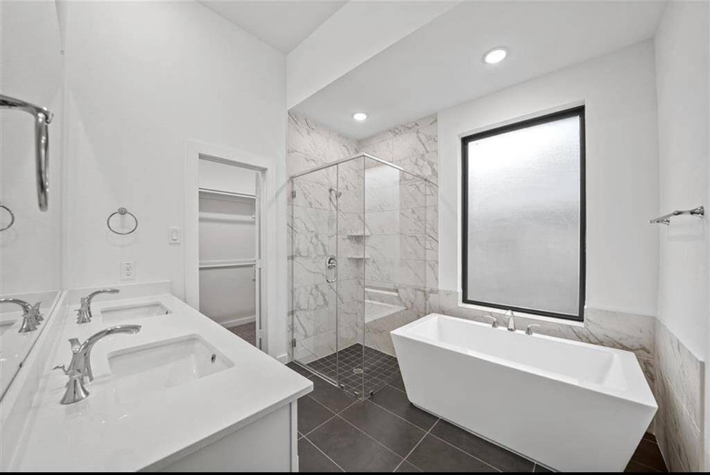 Primary spa like bathroom with freestanding tub and glass shower.