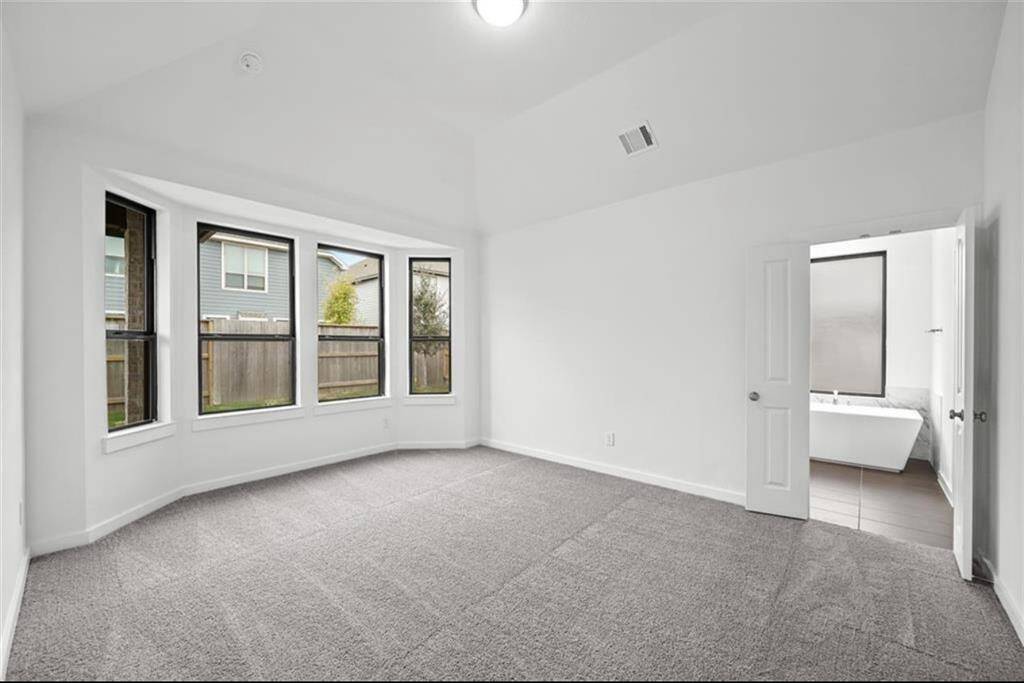 Vaulted ceiling in the family room and bay window gives open and roomy feel to primary bedroom.