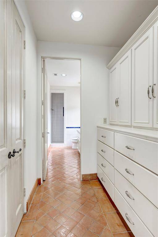 Closet and built-in cabinetry leading to ensuite bath