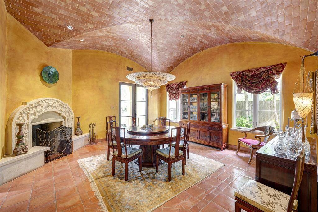 Dining room with groin vault ceiling, fireplace, hand painted silk chandelier, and access to a patio