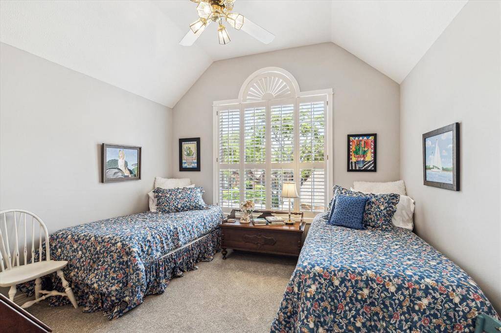 Upstairs bedroom overlooking the front lawn has high ceilings, ceiling fan and beautiful shuttered windows.