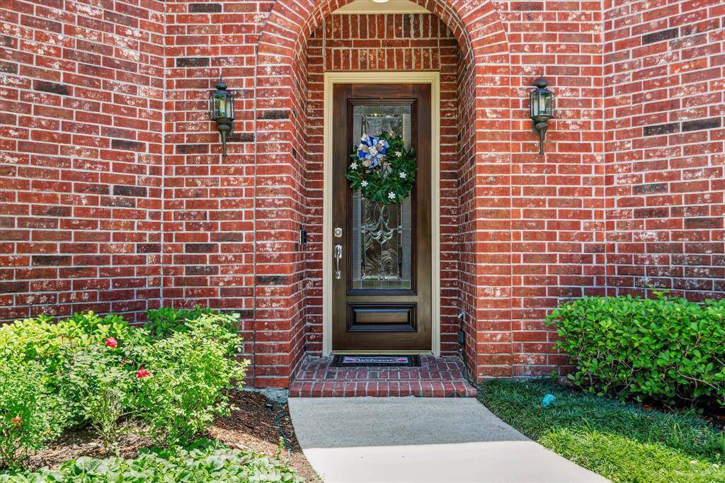 Front door is inviting with curved opening and pretty glass door leading to an incredibly gorgeous interior.
